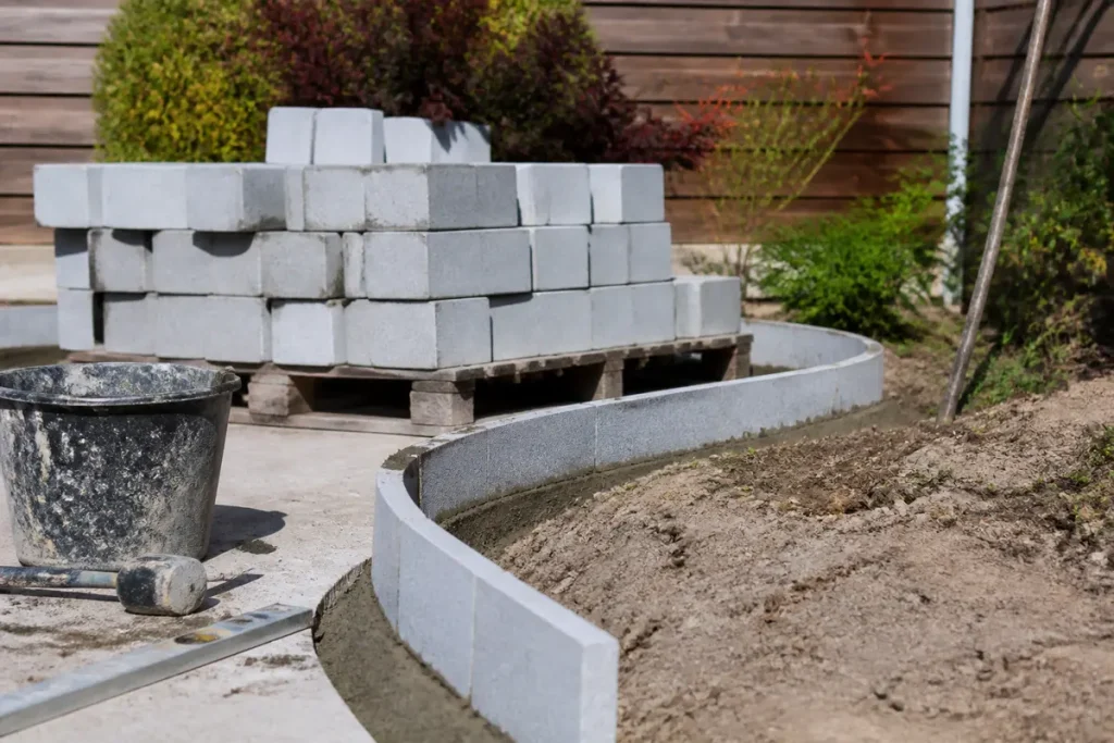 Construction d'une bordure de jardin fabrication maison avec parpaings et outils de bricolage